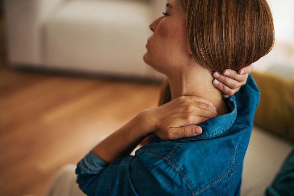Woman suffering from neck pain at home